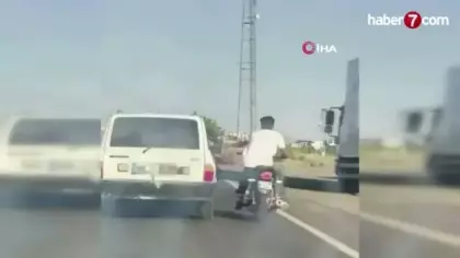 Şanlıurfa'da tehlikeli yolculuk: Motosiklet, otomobil kemerine tutunarak ilerledi